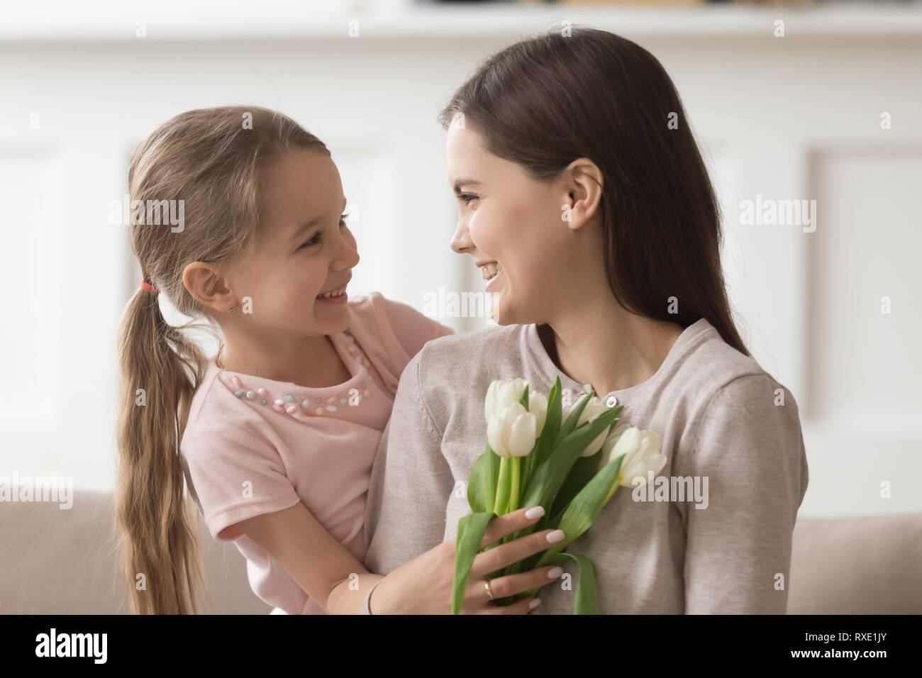 Happy mom fiori tenuta la festa della mamma regalo da graziosi kid Foto Stock