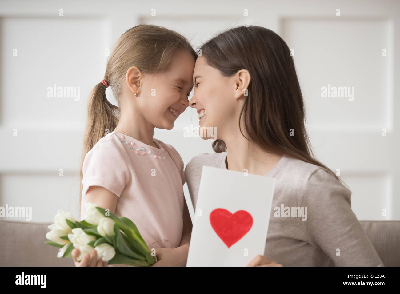 Felice mamma e figlia di capretto ridere per celebrare la festa della mamma insieme Foto Stock