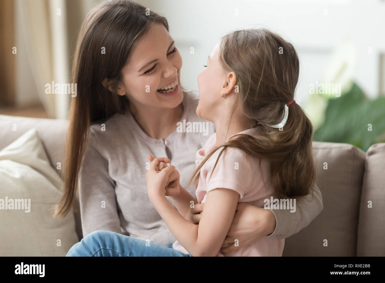 Sorridente carina ragazza di capretto e madre avendo divertimento ridere insieme Foto Stock