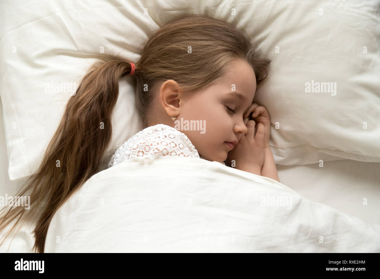 Carino calma bambina dormendo dormendo nel letto confortevole Foto Stock