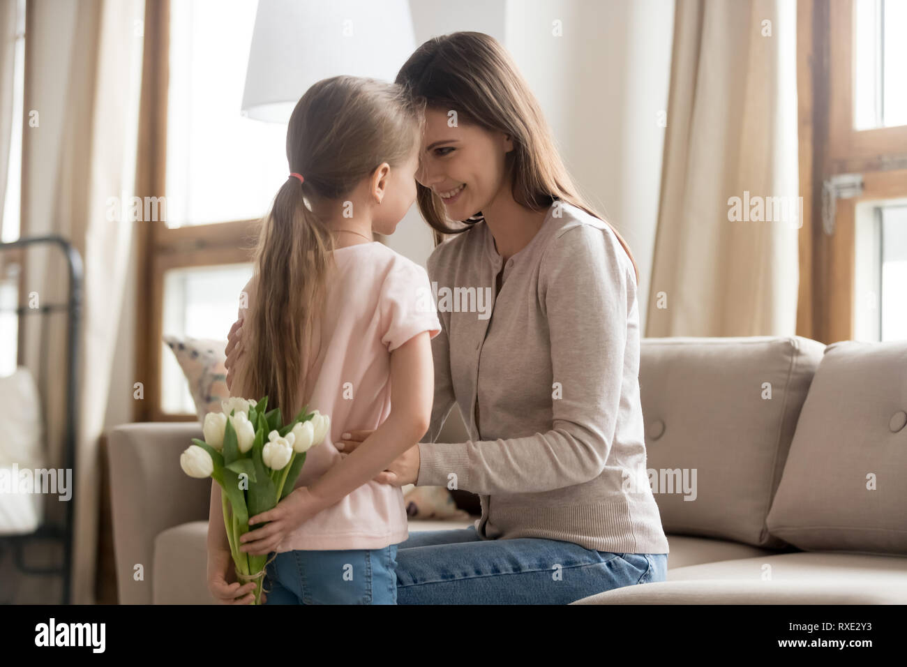 Figlia di capretto tenendo i tulipani congratularmi con felice la mamma con le madri giorno Foto Stock