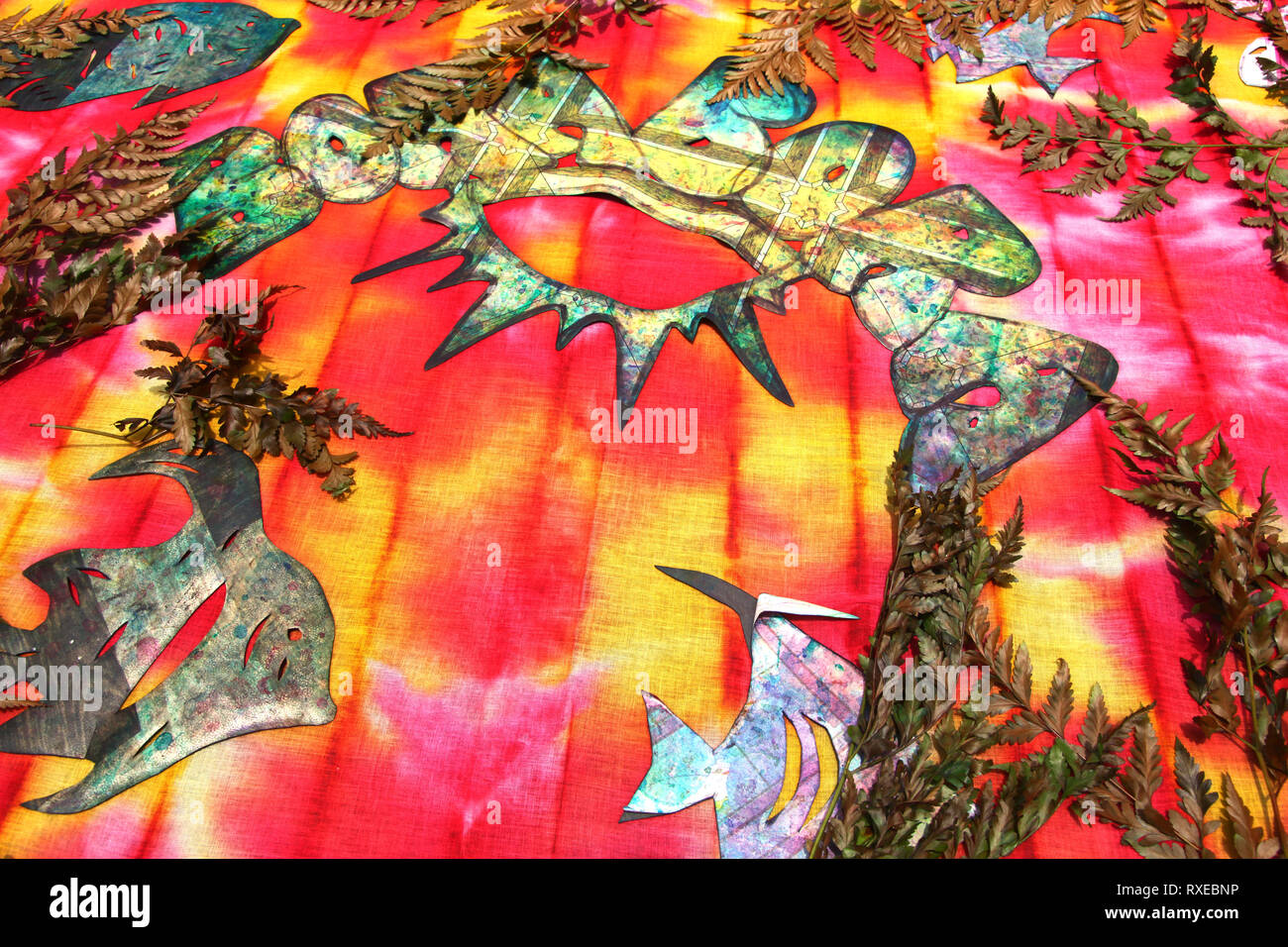 Tessuto colorato con foglie, felci & forme di carta ritagliata demonstraiting come creare tie dye progetta, Bora Bora, Polinesia francese. Foto Stock