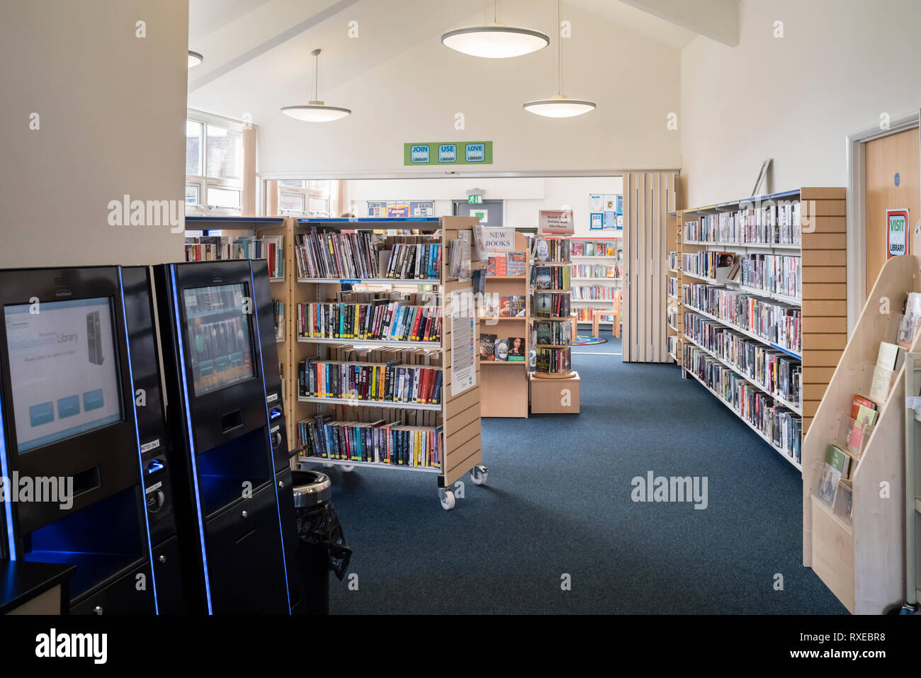 Un piccolo villaggio ramo interno della libreria con libri e di ritiro elettronico/ritorno, Wellesbourne, UK. Foto Stock