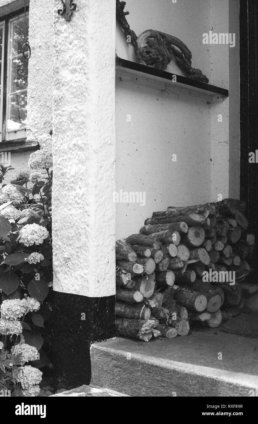 Portico frontale di quercia Cottage, North Bovey, Devon UK, con log-pila Foto Stock