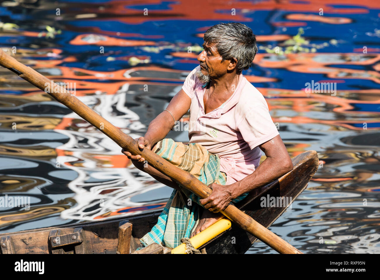 Dacca in Bangladesh, 24 Febbraio 2017: Ritratto di un vogatore nella sua vecchia barca in legno che serve come un traghetto tra le due rive del Buriganga Riv Foto Stock