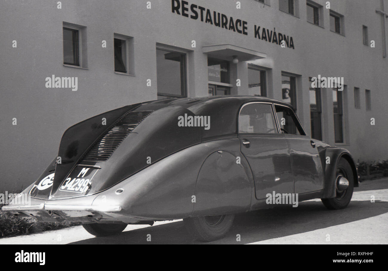 1930s, storico, una Tatra 77, un hotel di lusso a quattro porte posteriori propulsori di autoveicolo con un tailfin Parcheggiato fuori del ristorante Kavarna, Sudentenland, Cecoslovacchia. Prodotto da Tatra motor company in Koprivnice, Moravia, che ha iniziato la produzione di automobili nel 1897, questa avveniristica auto è stato il primo al mondo di produzione auto aerodinamica e il suo design sottile è stato rivoluzionario per il tempo. Foto Stock