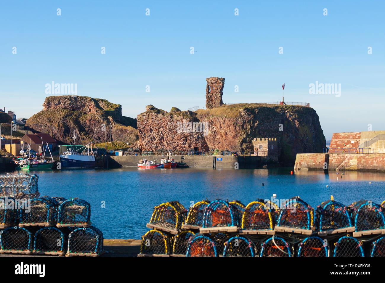 Dunbar porto e castello di Dunbar con aragosta cantre in primo piano. Sfondo. Dunbar, East Lothian, Scozia Foto Stock