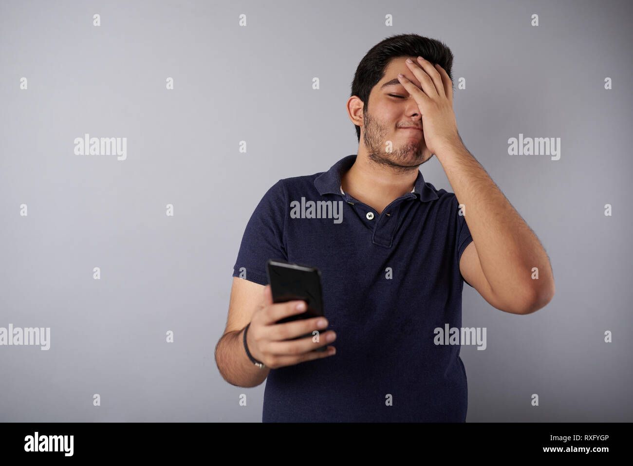 Sconvolto giovane uomo dopo la lettura di notizie nello smartphone Foto Stock