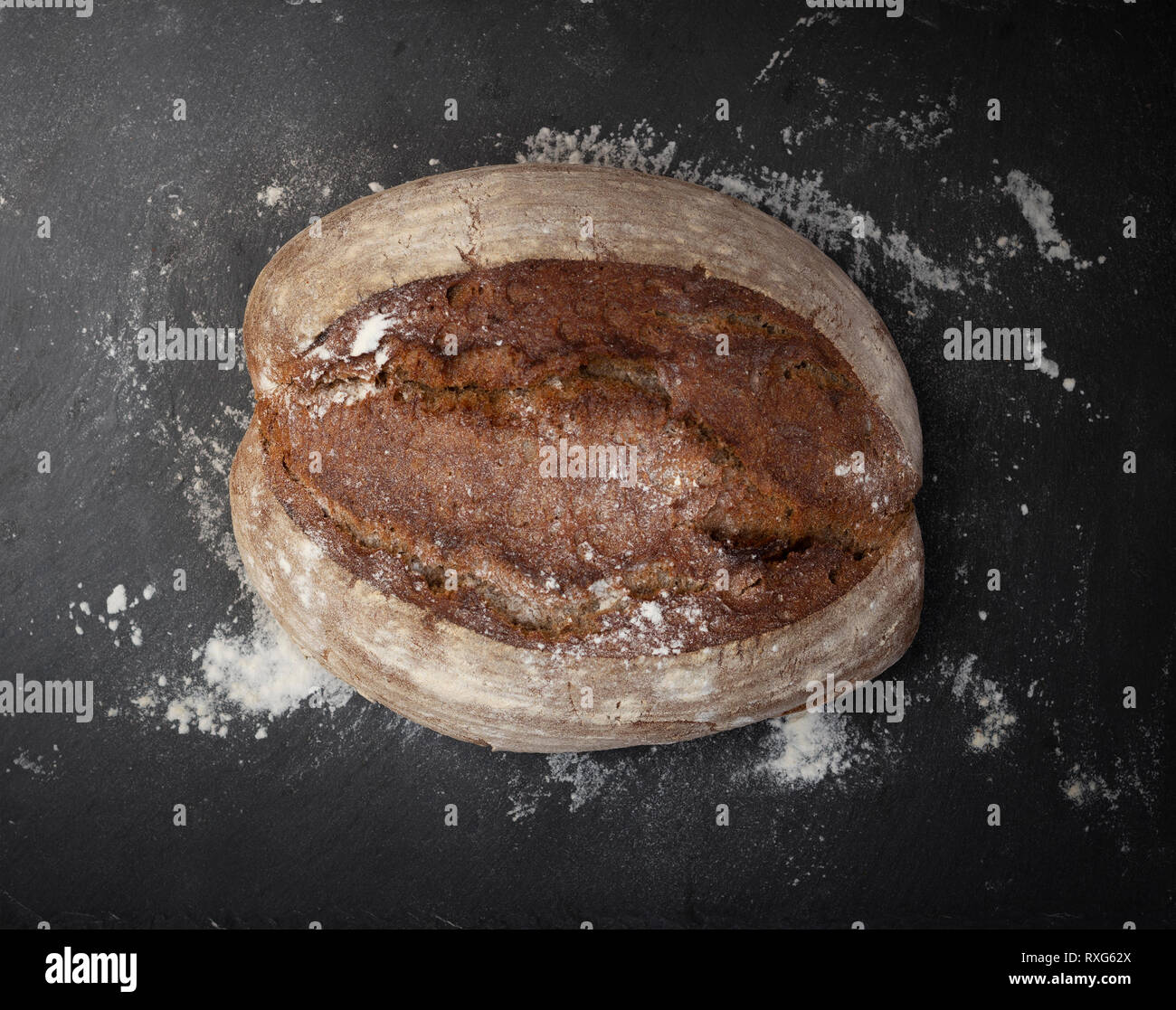 Tutto il pane e disseminati di farina bianca su sfondo scuro Foto Stock