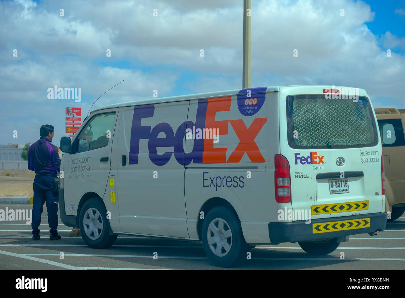 Febbraio 13, 2019 - Abu Dhabi, Emirati arabi uniti: FedEx Express delivery van e il giovane persona consegna ad Abu Dhabi, Emirati arabi uniti Foto Stock