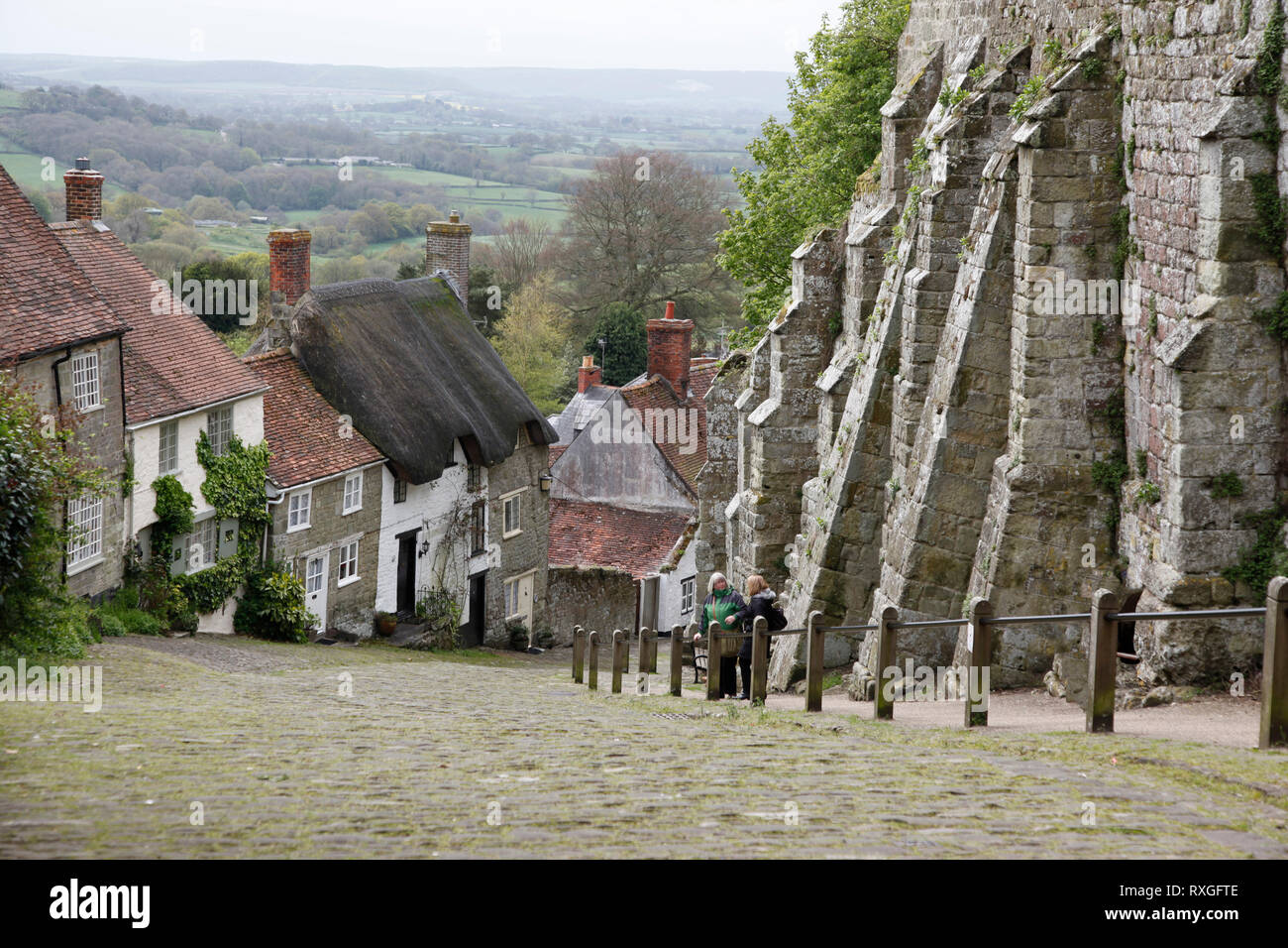 Visualizza in basso ripida collina d'oro, con caratteristico e dal tetto di paglia cottages in Shaftesbury, Dorset, England, Regno Unito Foto Stock