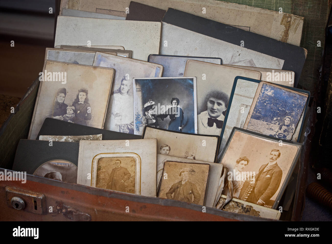 Una valigia piena di vecchie fotografie vintage nella vetrina di un negozio di carità a Edimburgo, Scozia. Foto Stock