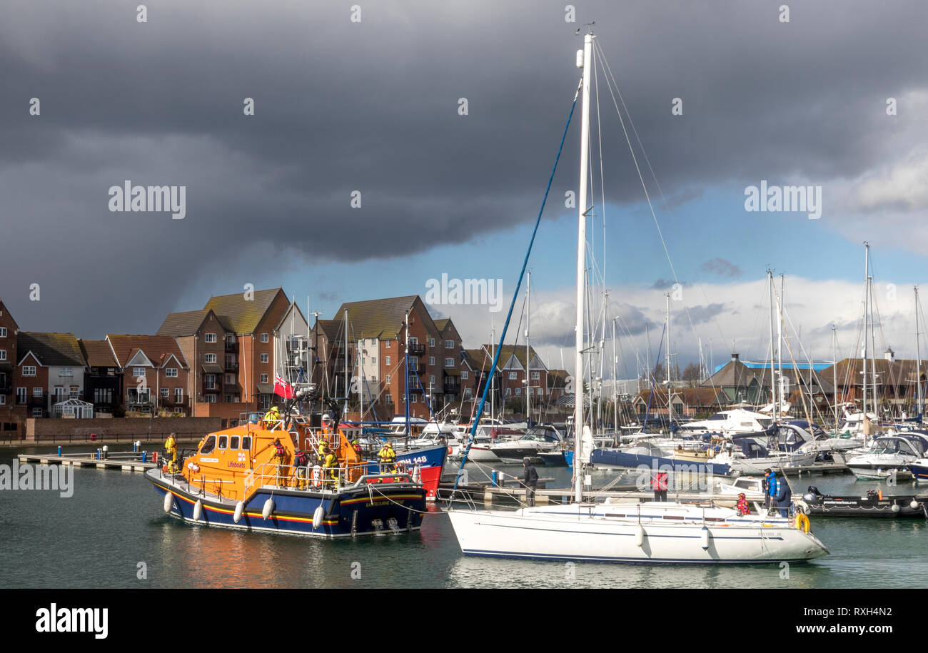 Sovereign Harbour, Eastbourne, East Sussex, Regno Unito. Il 10 marzo 2019. La Eastbourne RNLI Tutti Meteo scialuppa di salvataggio ritorna al porto dopo aver risposto a una richiesta di assistenza dalla barca a vela "Canberra Star", una Bavarian 38 piedi barca a vela che erano ripartiti in mare mosso al largo della costa meridionale della East Sussex. La nave e il suo equipaggio sono stati recuperati in modo sicuro al Porto di sovrani in traino. Foto Stock