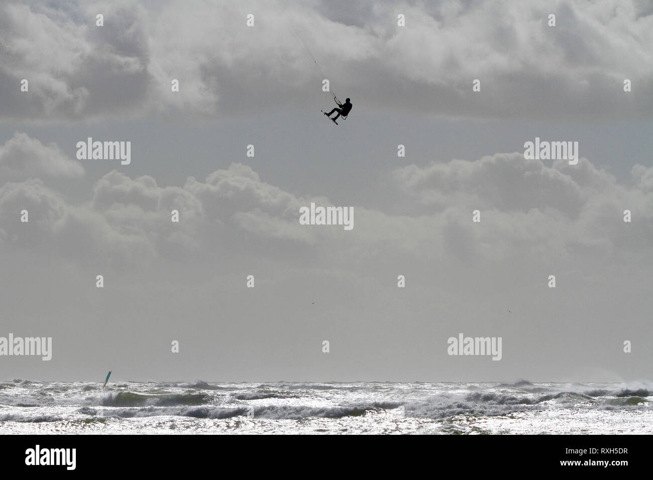 West Strand, West Wittering, Sussex, Regno Unito. Il 10 marzo 2019. Severe gales lungo la costa sud di oggi con raffiche di oltre 60 km/h. Quattro volte campione britannico Kitesurfer Lewis Crathern, famosa per il suo salto kitesurfer oltre il molo di Brighton, in azione a 2XS sport acquatici a West Wittering beach in West Sussex. Credito: James jagger/Alamy Live News Foto Stock