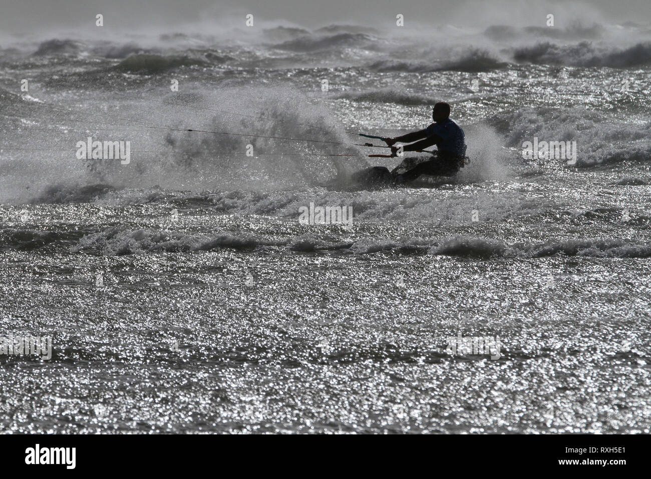 West Strand, West Wittering, Sussex, Regno Unito. Il 10 marzo 2019. Severe gales lungo la costa sud di oggi con raffiche di oltre 60 km/h. Quattro volte campione britannico Kitesurfer Lewis Crathern, famosa per il suo salto kitesurfer oltre il molo di Brighton, in azione a 2XS sport acquatici a West Wittering beach in West Sussex. Credito: James jagger/Alamy Live News Foto Stock