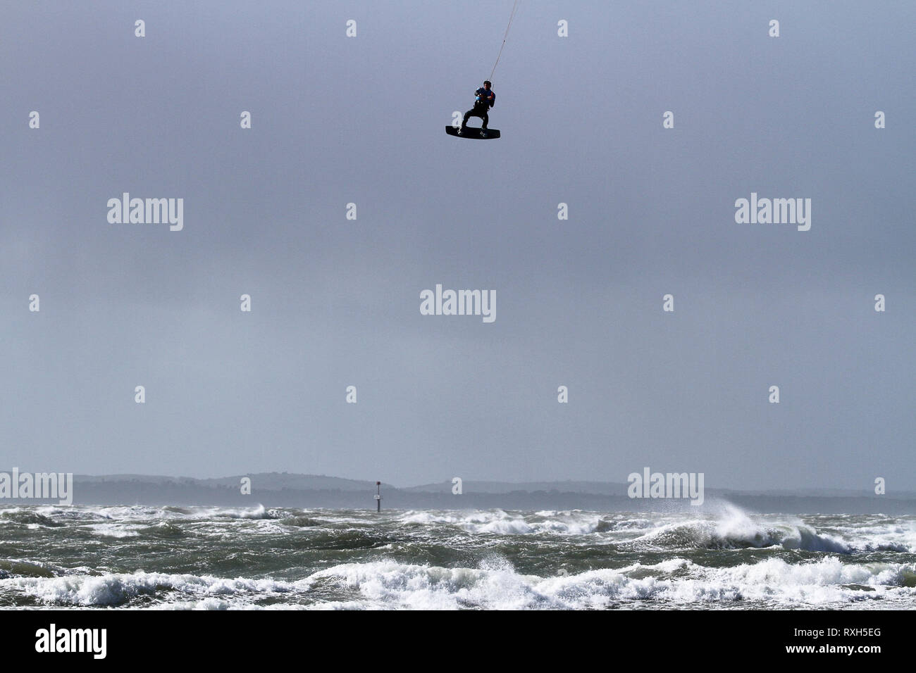West Strand, West Wittering, Sussex, Regno Unito. Il 10 marzo 2019. Severe gales lungo la costa sud di oggi con raffiche di oltre 60 km/h. Cinque volte PKRA Kitesurf Campione del Mondo, Aaron Hadlow, in azione a 2XS sport acquatici a West Wittering beach in West Sussex. Aaron è da Hayling Island e ha vinto due volte il Red Bull re della concorrenza aria in Sud Africa Credito: James jagger/Alamy Live News Foto Stock