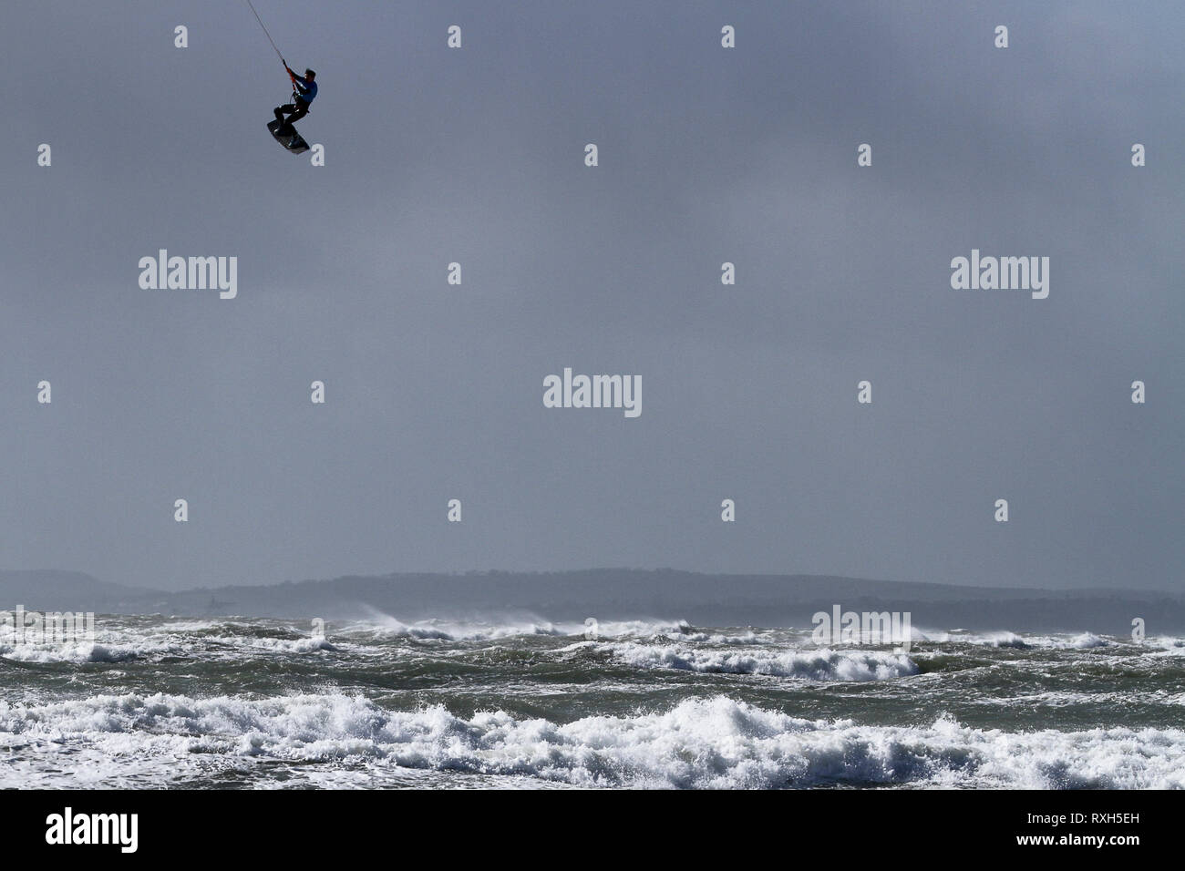 West Strand, West Wittering, Sussex, Regno Unito. Il 10 marzo 2019. Severe gales lungo la costa sud di oggi con raffiche di oltre 60 km/h. Cinque volte PKRA Kitesurf Campione del Mondo, Aaron Hadlow, in azione a 2XS sport acquatici a West Wittering beach in West Sussex. Aaron è da Hayling Island e ha vinto due volte il Red Bull re della concorrenza aria in Sud Africa Credito: James jagger/Alamy Live News Foto Stock