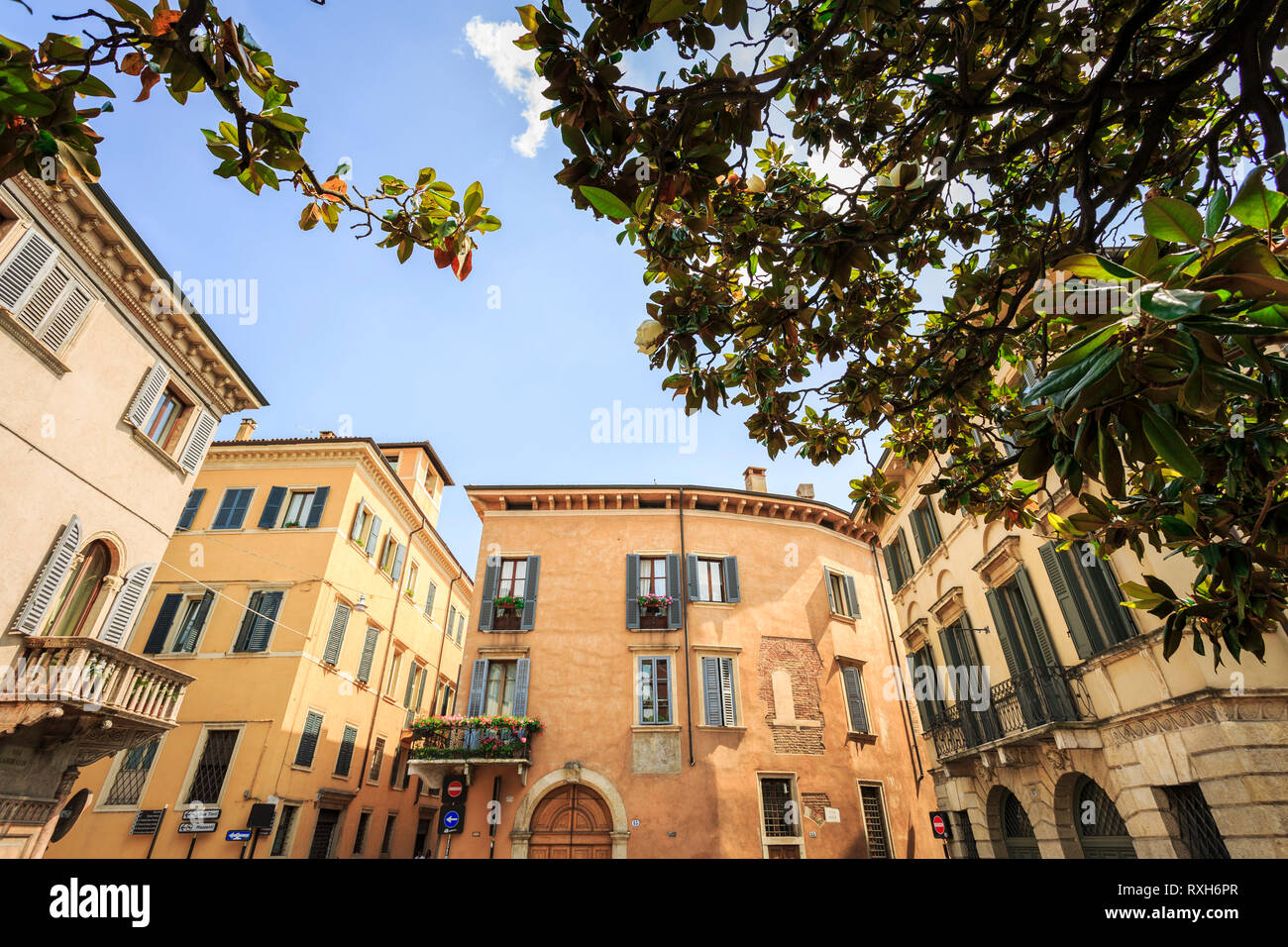 Ripresa a tutto campo con case colorate con i fiori sui balconi e alle finestre in una giornata di sole. Verona, Italia. Foto Stock