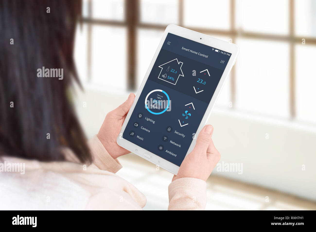 Donna utilizzare smart home app di controllo per impostare la temperatura e illuminazione. Soggiorno, home concetto di gestione. Foto Stock