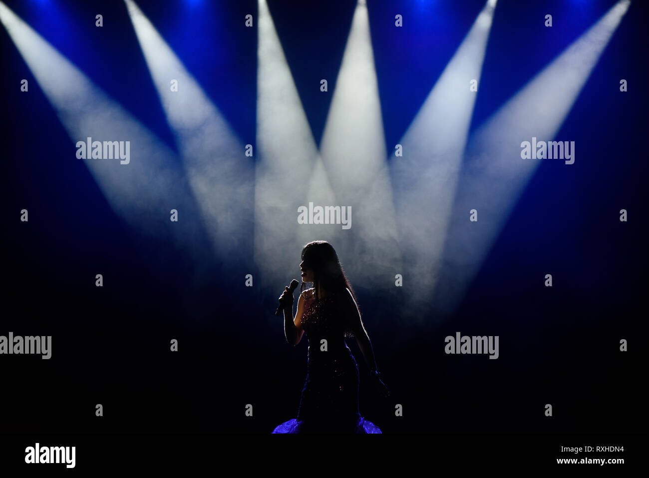 Il cantante in silhouette. Una giovane donna cantante sul palco durante un concerto. Foto Stock