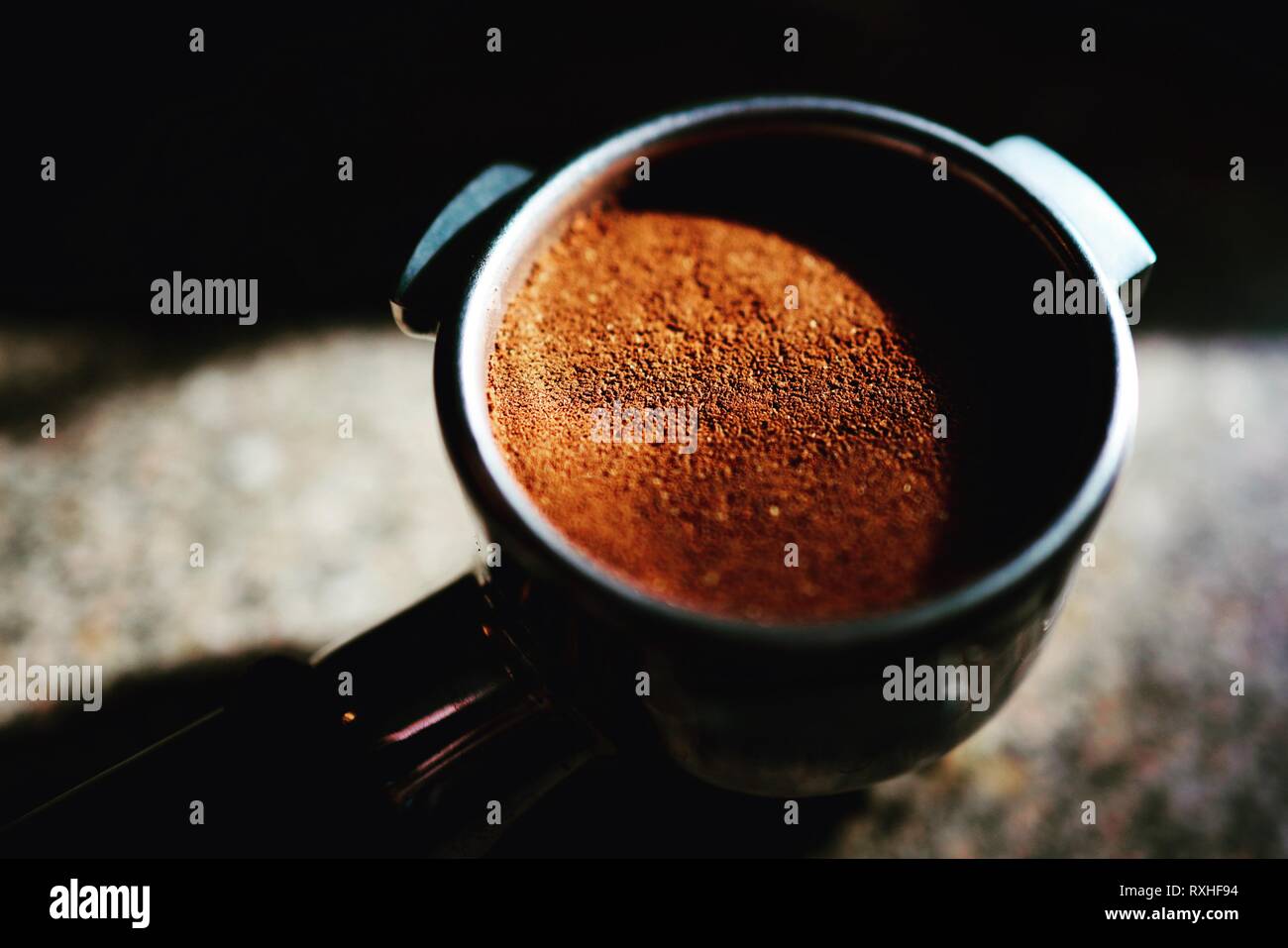 Caffè appena macinato nel filtro porta pronto per essere estratto Foto Stock