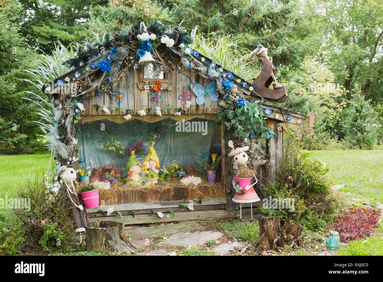 Decorate il legno vecchio plank giocattolo in miniatura casa con vari visualizzati bambole, figurine sul cortile anteriore di una casa residenziale in tarda estate, Quebec, Canada. Questa immagine è di proprietà rilasciato. CUPR0298 Foto Stock