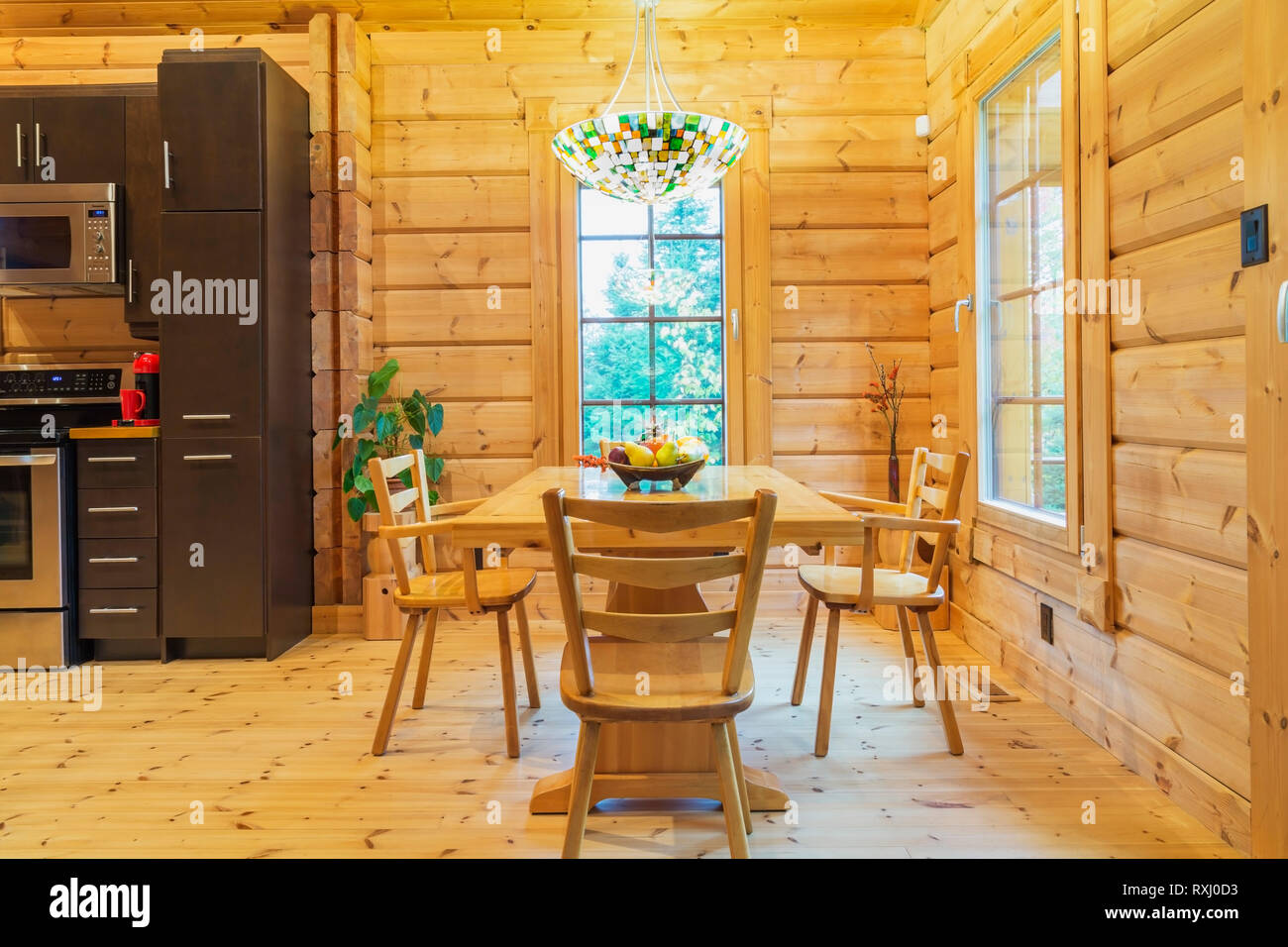 Vista parziale in legno naturale countertop e mobili marroni, dispensa con  forno a microonde e tavolo da pranzo in legno all'interno di un pezzo sur  pezzo casa di legno di pino scozzese,