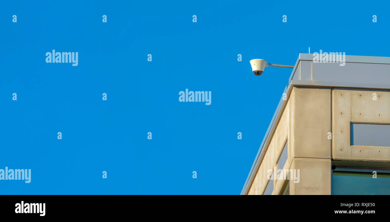 Una telecamera di sicurezza di un edificio con lo sfondo del cielo Foto Stock