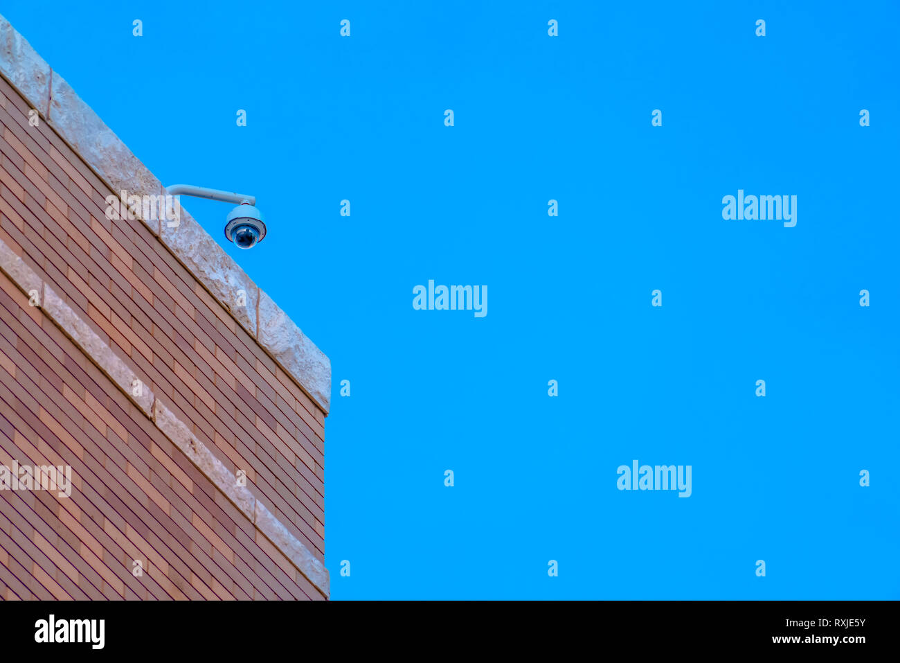 Videocamera di sicurezza su un edificio contro il cielo blu Foto Stock