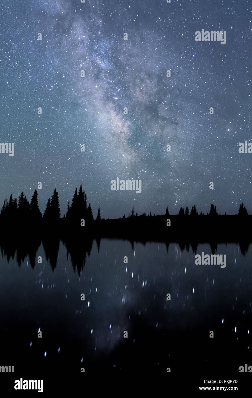 La Via Lattea e il suo centro galattico si riflette un alto lago alpino in Snowy Range del Wyoming. Foto Stock