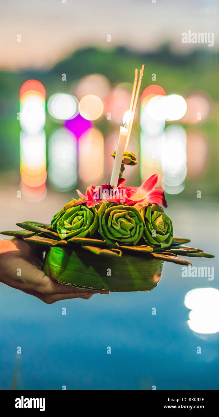 Giovane donna celebra Loy Krathong, corre sull'acqua. Loy Krathong festival, la gente compra i fiori e candela alla luce e galleggiare su acqua per celebrare Foto Stock