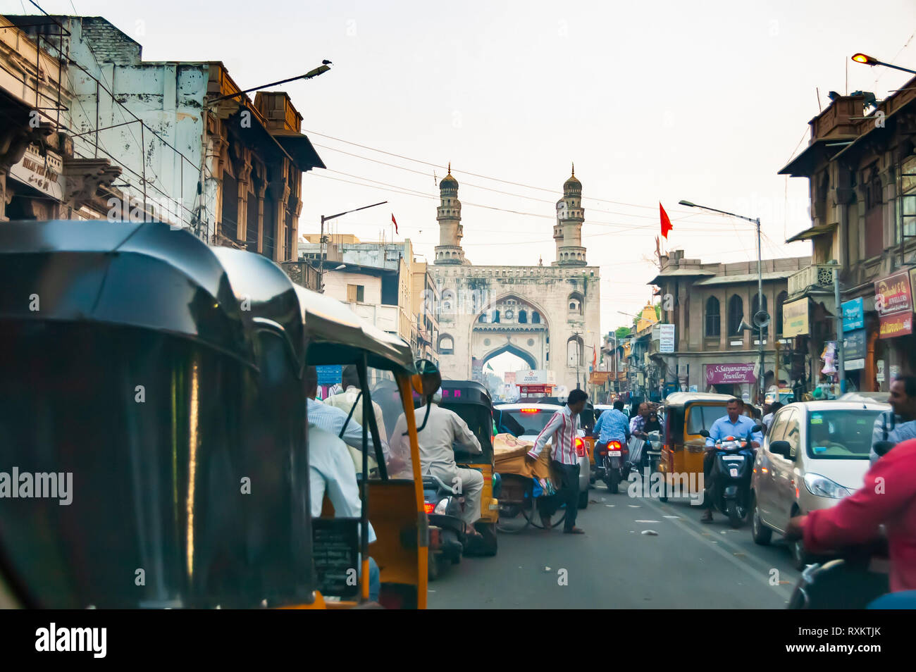 Persone e veicolo spintoni per lo spazio occupato, affollata e piena zeppa di strade di Charminar e Char Kaman, Hyderabad, Telangana, India. Foto Stock