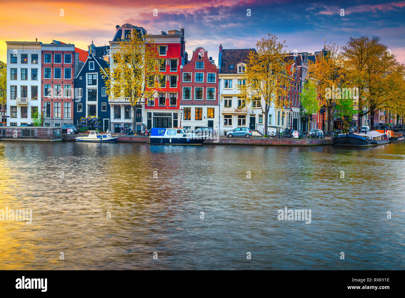 Spettacolari Viaggi e Località turistica, fantastico skyline della città con case olandesi tradizionali. Canale d'acqua con case galleggianti al tramonto, Amsterdam, Nethe Foto Stock
