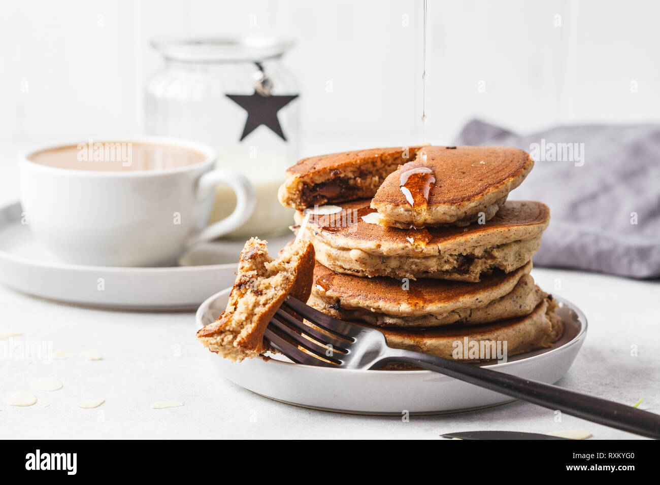 Frittelle di cioccolato ripiene su una lastra grigia con caffè per colazione. Foto Stock