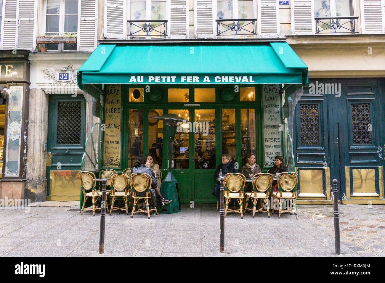 Patroni godendo il caffè pomeridiano presso il cafe Au Petit Fer a cheval nel quartiere Marais di Parigi, Francia. Foto Stock