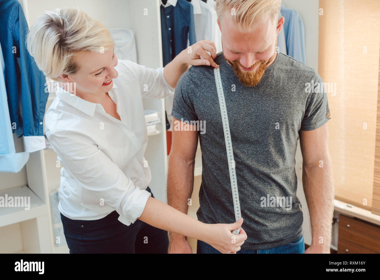 Adattare la misura il cliente con nastro di misurazione Foto Stock