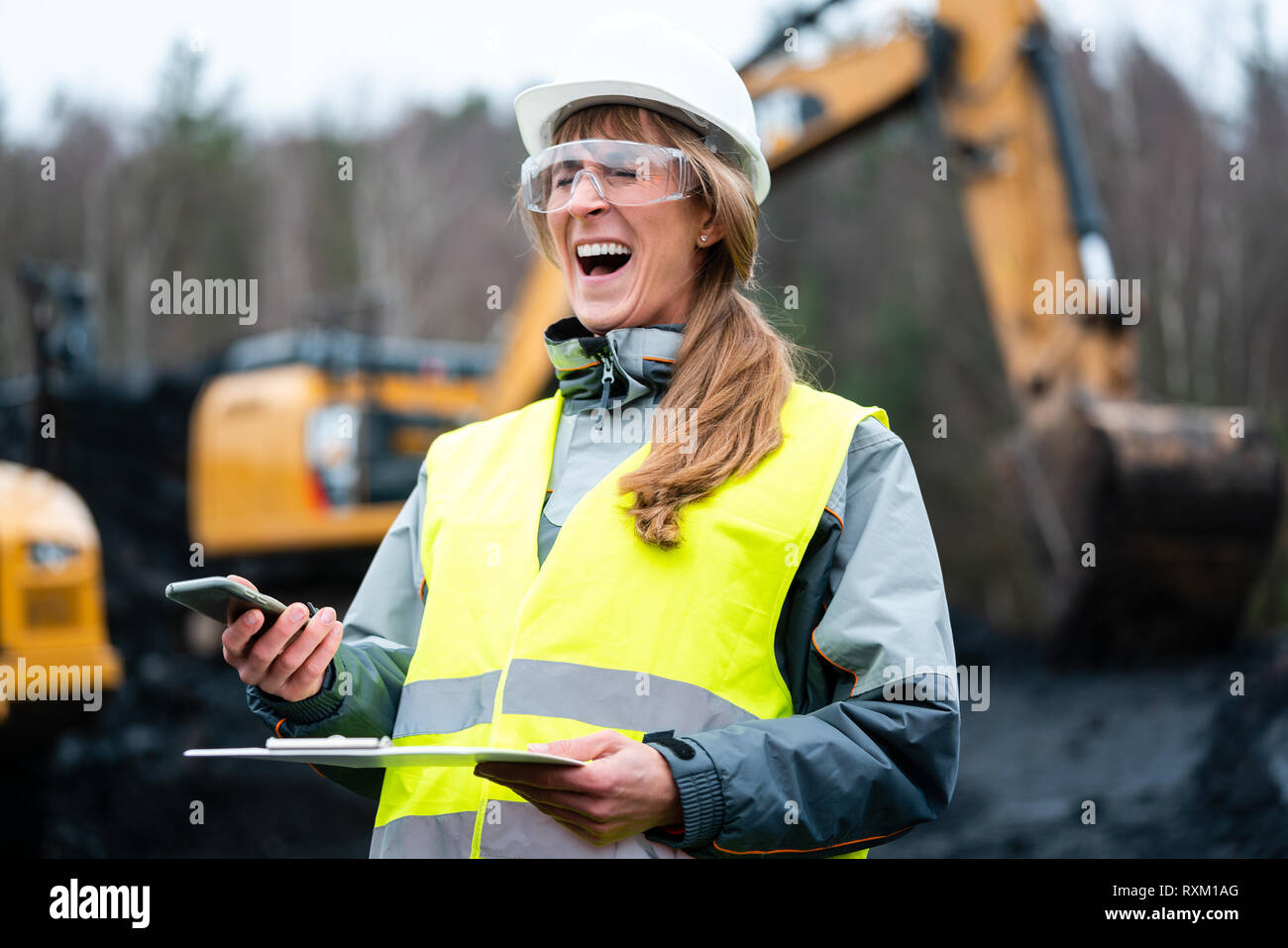 Lavoratore donna in le miniere a cielo aperto usando il telefono Foto Stock