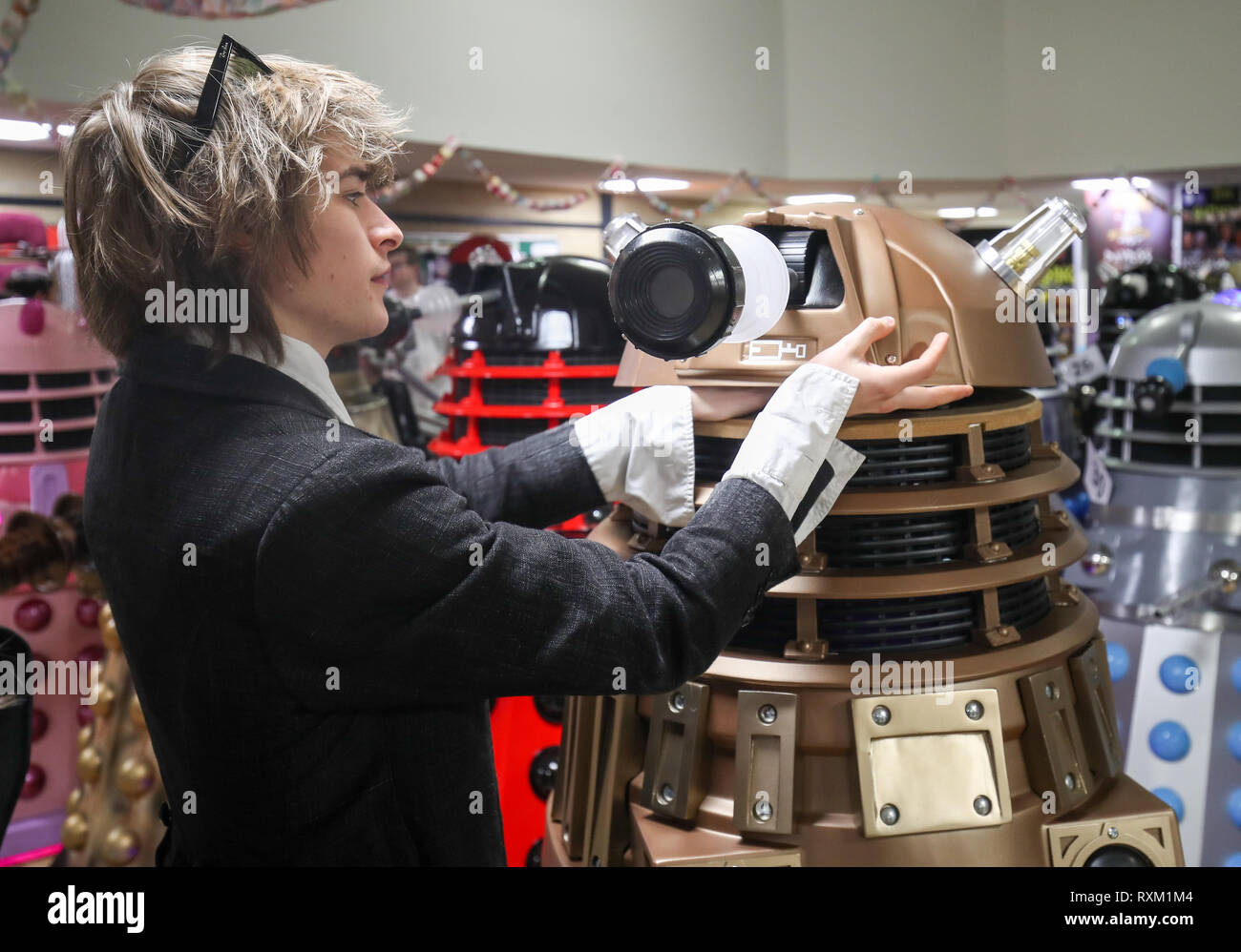 Una persona regola la parte superiore del suo Dalek come essi sono riuniti in una camera di contenimento prima di un tentativo di record mondiale per la maggior parte Daleks in un unico luogo durante la 'Raccolta', un medico che la carità a tema evento all'Olimpiade Leisure Centre in Chippenham, Wiltshire. Foto Stock