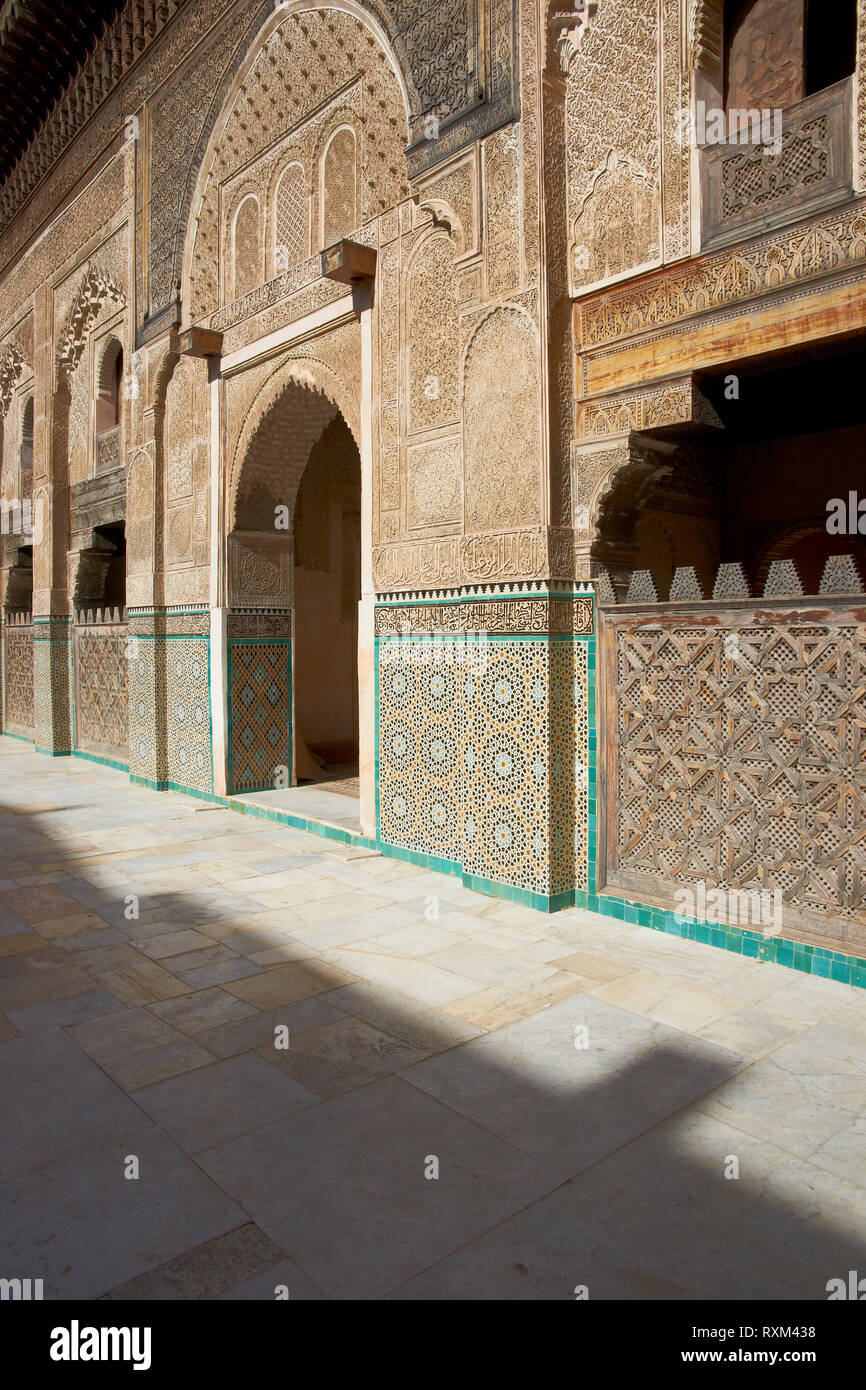 Carving ornati sulle pareti intonacate e sul lavoro di legno nel cortile della storica Madrasa Bou Inania nell'antica medina di Fes in Marocco. Foto Stock