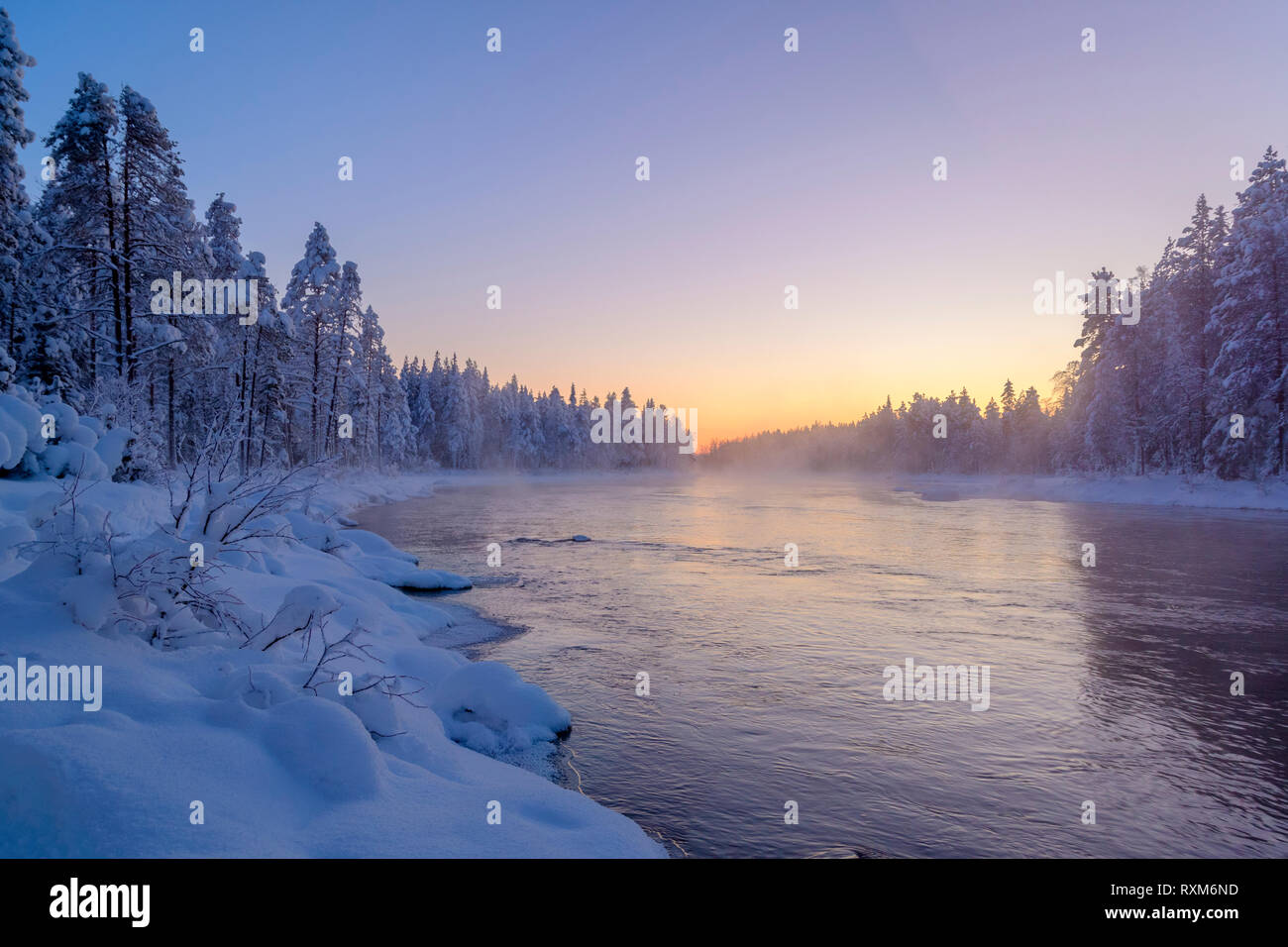 La nebbia e la nebbia che salgono dal mare aperto di un fiume di streaming durante un freddo e chiaro tramonto a -30º C, Kiveskoski River, Kuusamo, Finlandia Foto Stock