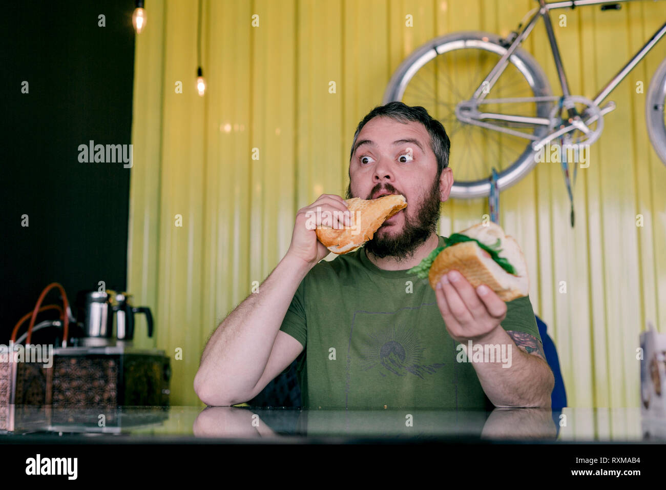 L'uomo affamato che mangia un panino Foto Stock