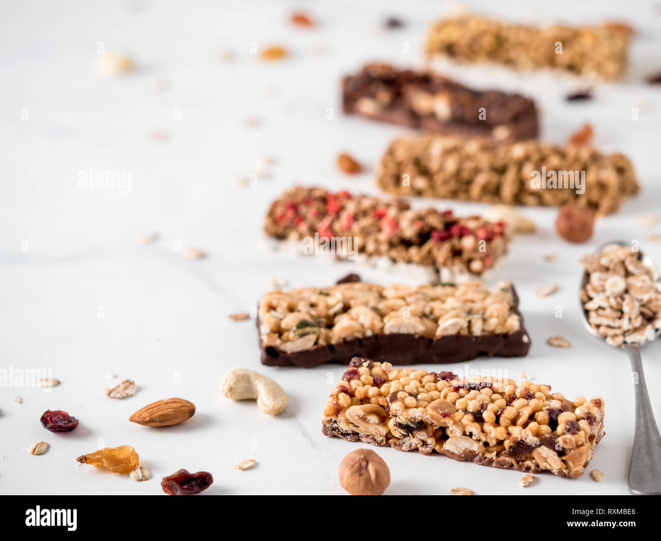 Granola bar con spazio di copia. Insieme di diversi granola bar su marmo bianco tavola. DOF poco profondo. Foto Stock