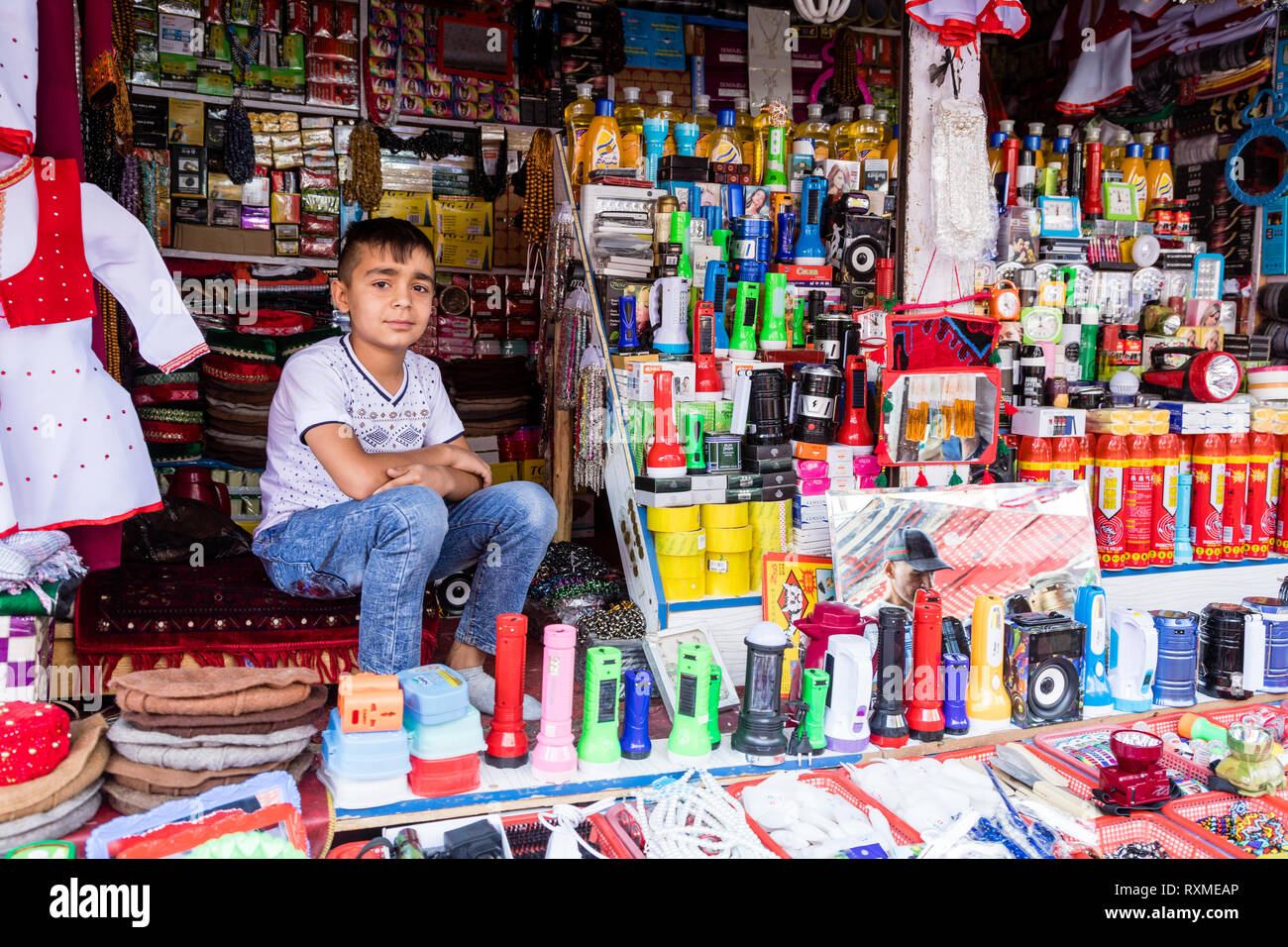 Khorog, Tagikistan 25 Agosto 2018: bel ragazzo è seduto nel suo stallo, in attesa di acquirente della sua mercanzia, Khorog, Tagikistan Foto Stock