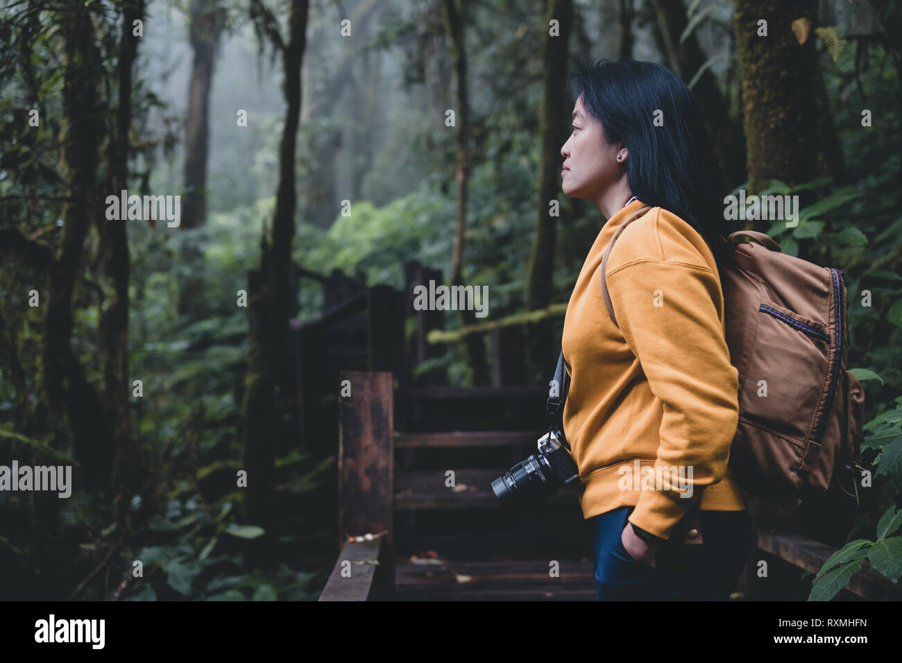 Asian backpacker guardando a vista nella foresta di pioggia nutural trail.banner mock up lascia una copia dello spazio per l'aggiunta di testo Foto Stock