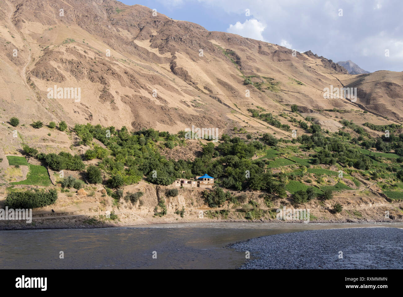 Afghanistan con il fiume Panj e case nella luce della sera Foto Stock