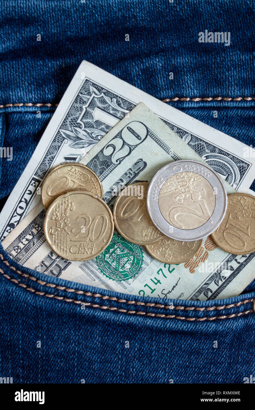 Diversi tipi di carta e metallo denaro sono giacenti in una tasca dei jeans. Lo stile di vita moderno. Foto Stock