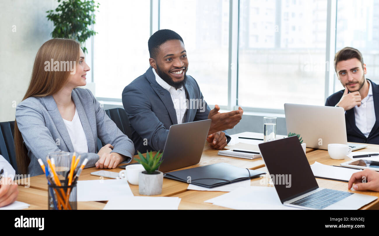 Giovane team aziendale analisi di grafici e diagrammi a riunione Foto Stock