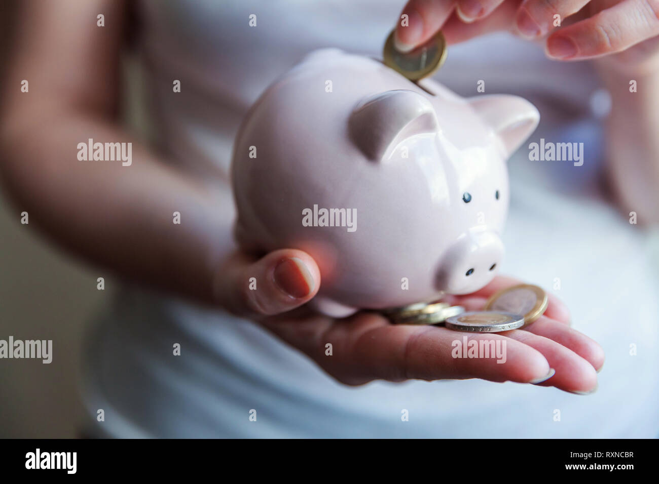 Donna femmina mani rosa salvadanaio e mettere il denaro Euro moneta. Salvataggio di bilancio degli investimenti aziendali pensionamento della ricchezza finanziaria delle banche di denaro concept Foto Stock