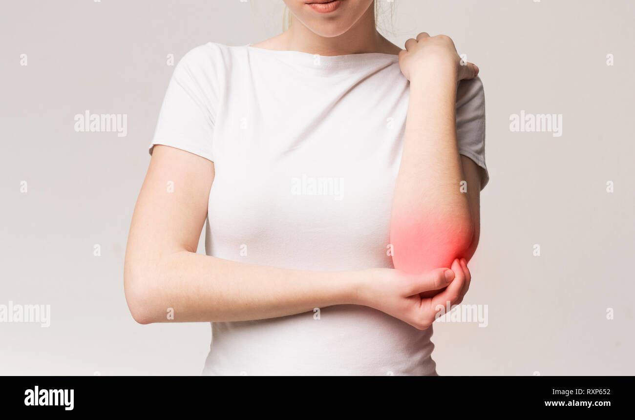 Ritagliato giovane donna che soffre di gomito doloroso Foto Stock