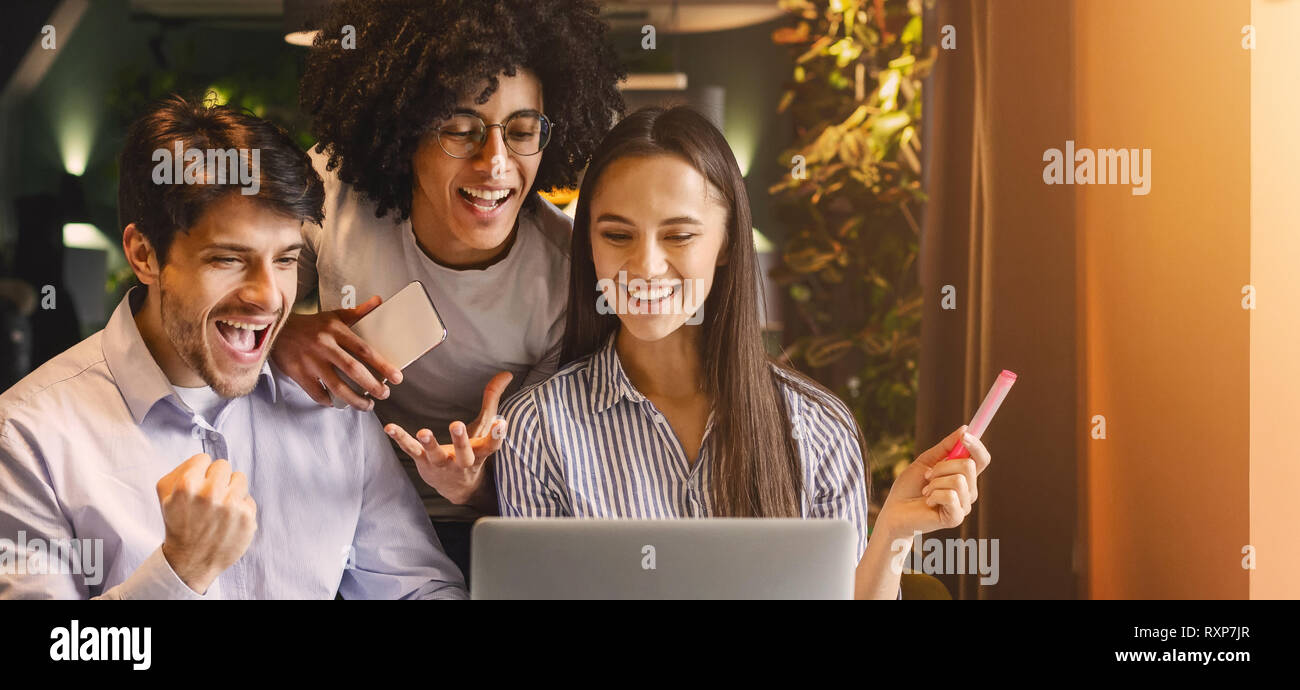 Il successo del team aziendale guardando felicemente laptop Foto Stock